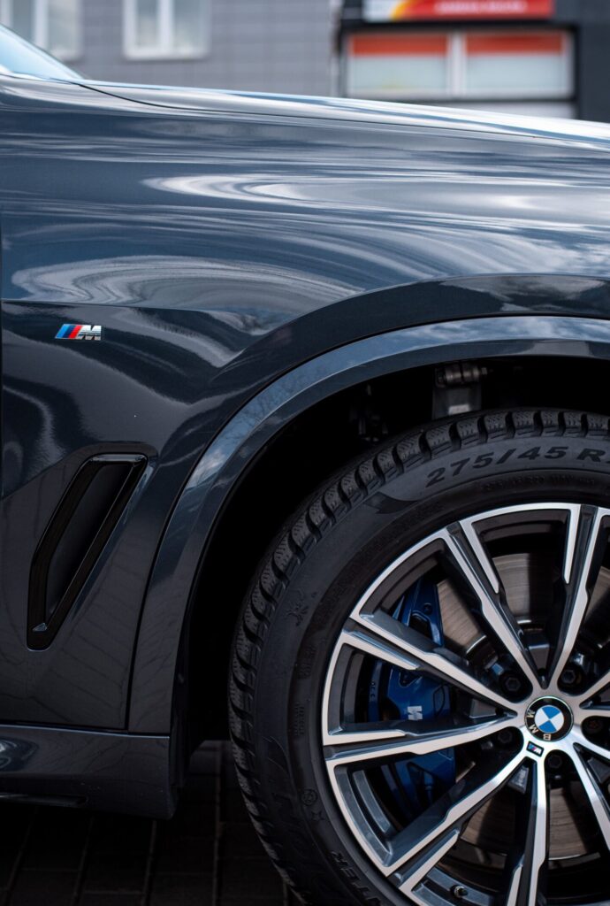 Detailed view of a BMW car fender and wheel rim highlighting luxury automotive design.