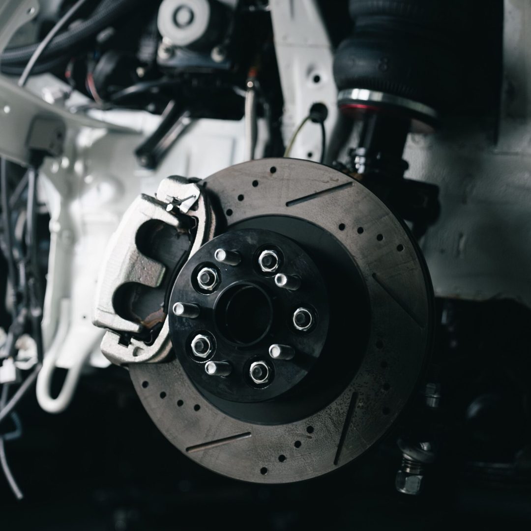 Detailed view of a vehicle's disc brake system with caliper, showcasing automotive technology.