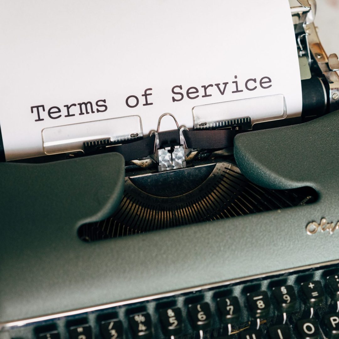 Close-up of a vintage typewriter printing 'Terms of Service' on paper, ideal for legal and business themes.